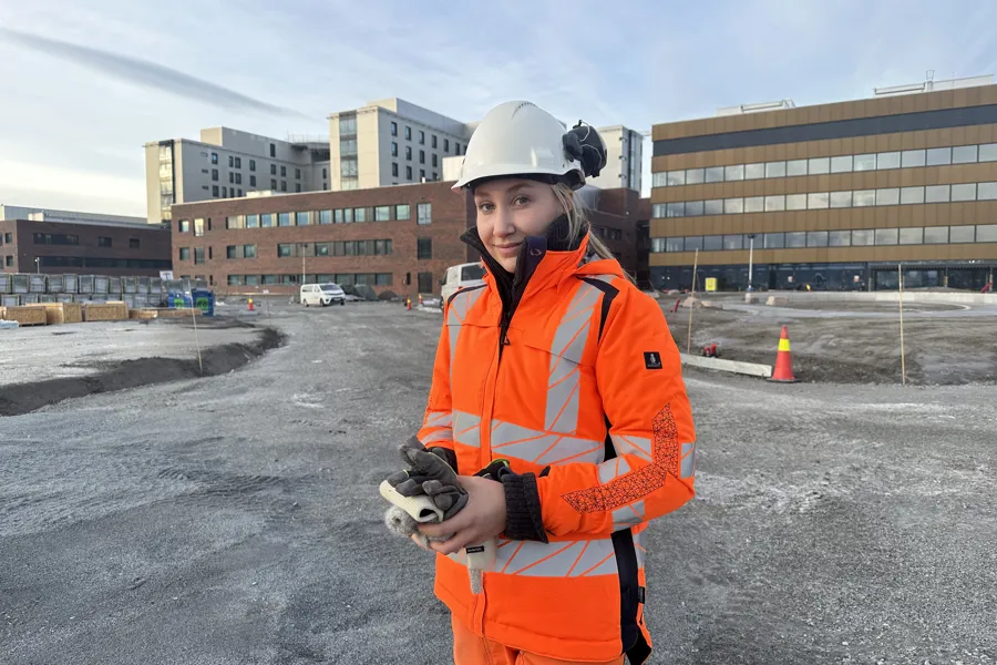 En person som har på seg sikkerhetsvest og holder et utstyr