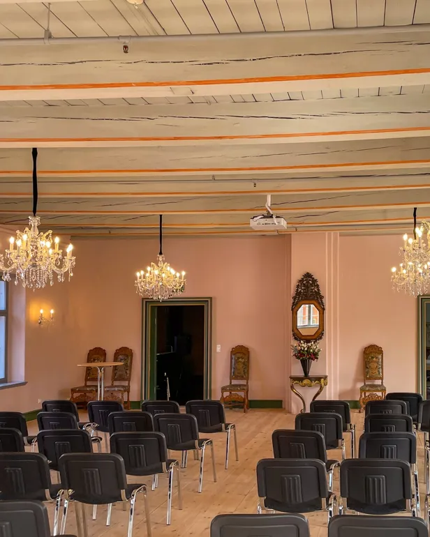 Et rom med lysekrone og stoler