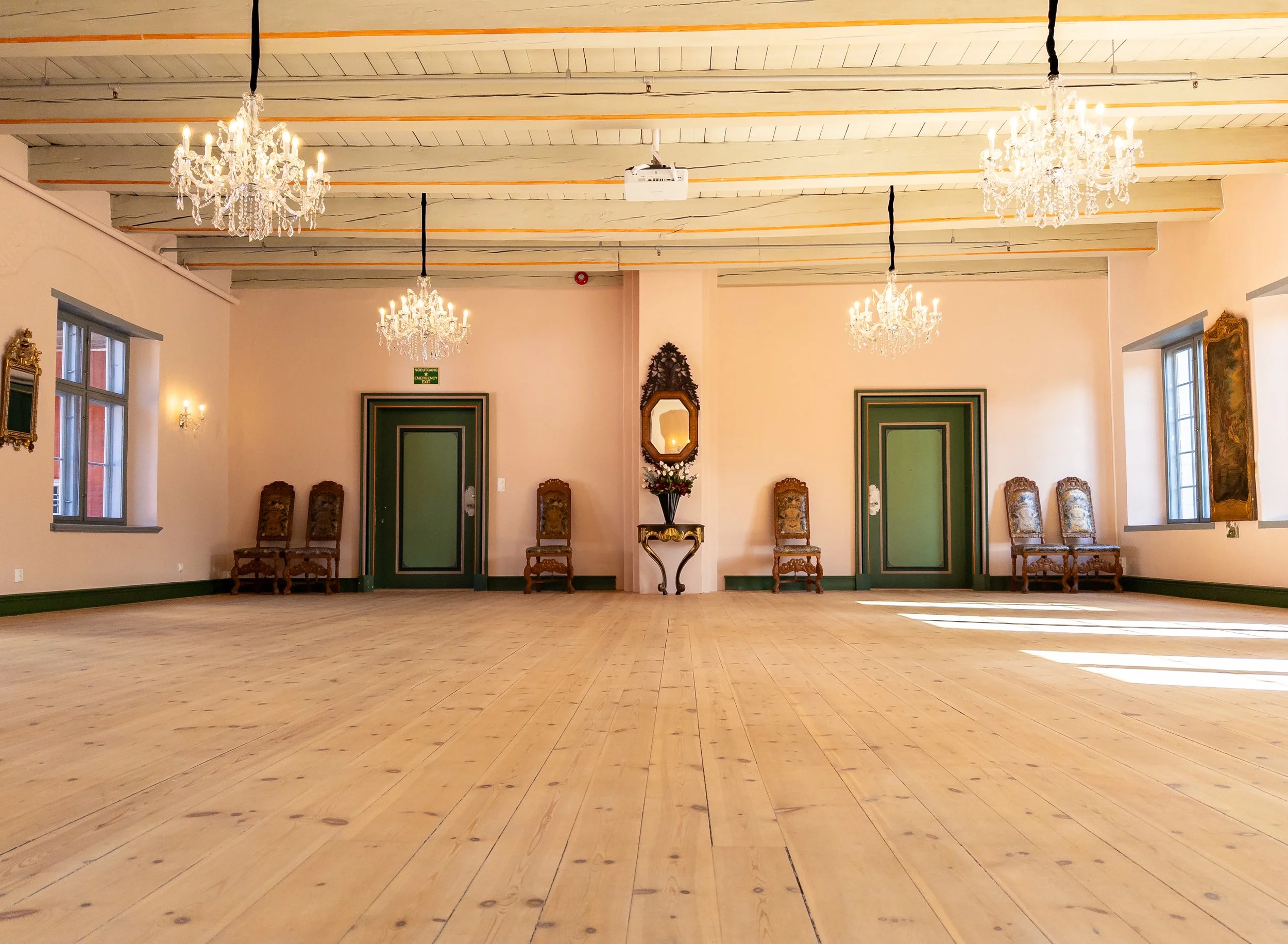 Et stort rom med lysekroner og stoler