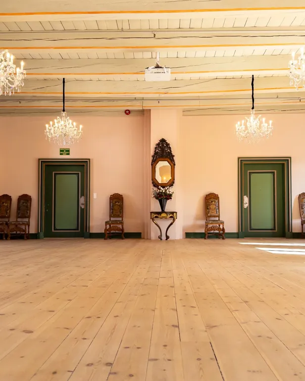 Et stort rom med lysekroner og stoler