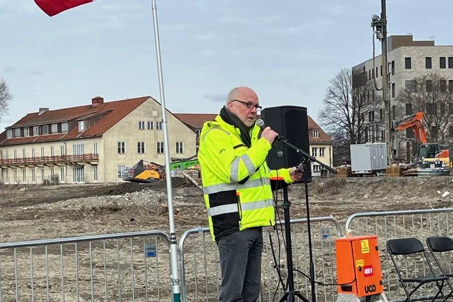 En mann som står ved siden av et flagg