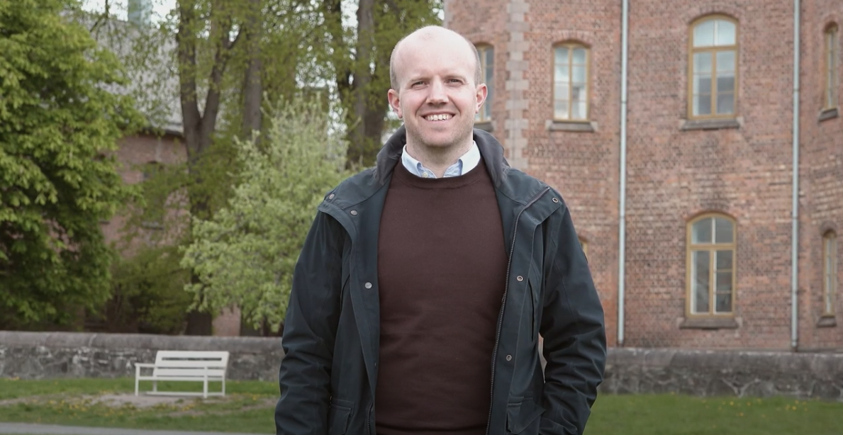 En mann som står foran en murbygning