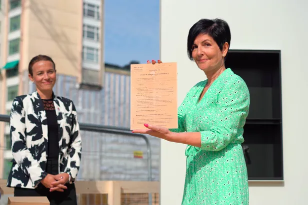 Dame viser frem sertifikat