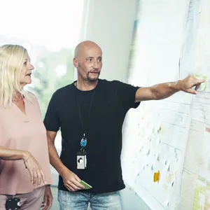 En mann som viser en kvinne noe på en hvit tavle