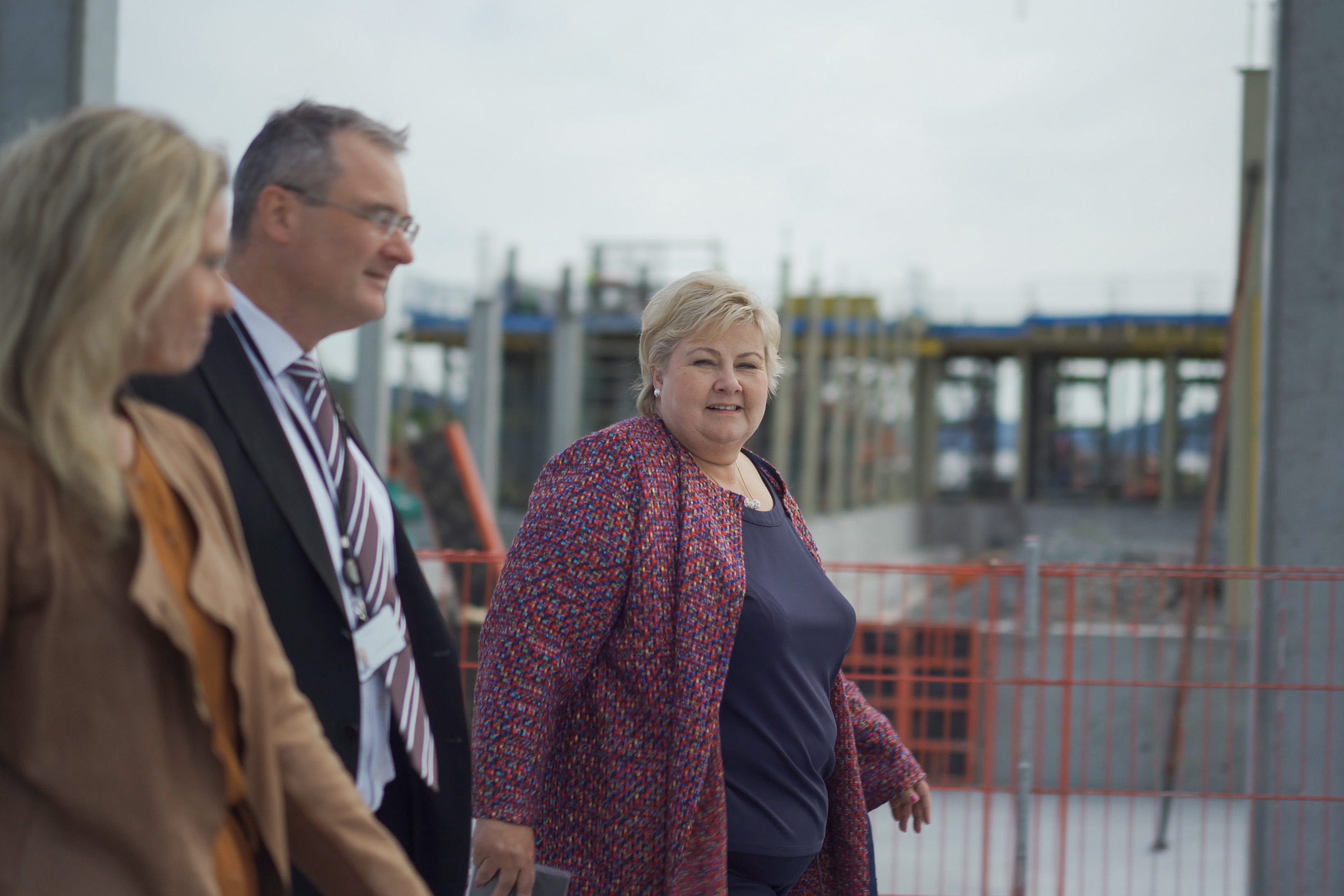 Tre personer går mens de snakker