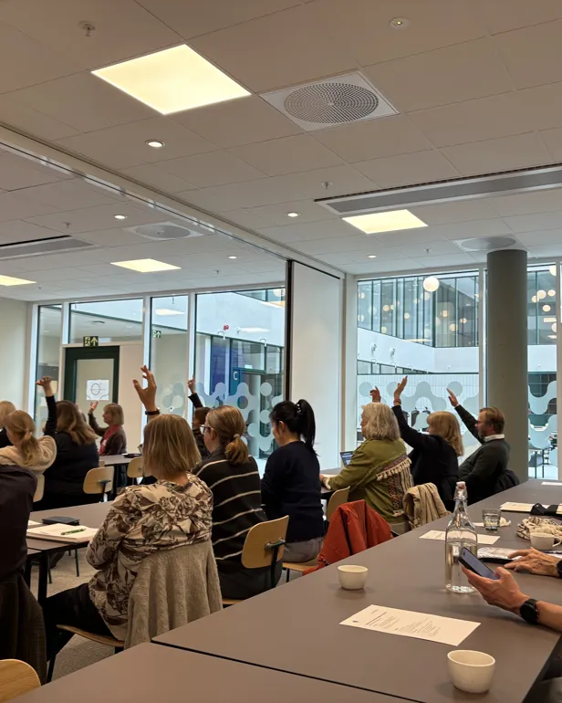 En gruppe mennesker som sitter ved bord