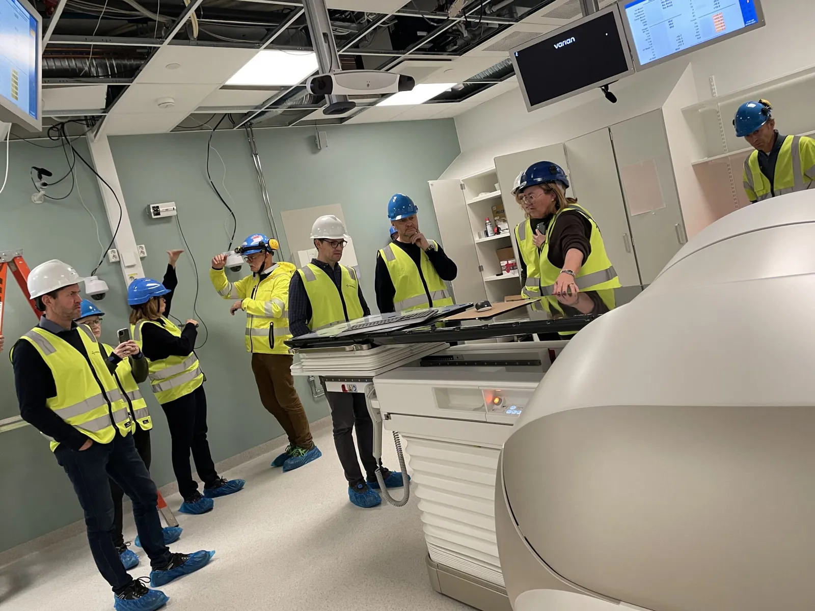 En gruppe mennesker i sikkerhetsvester som står i et rom