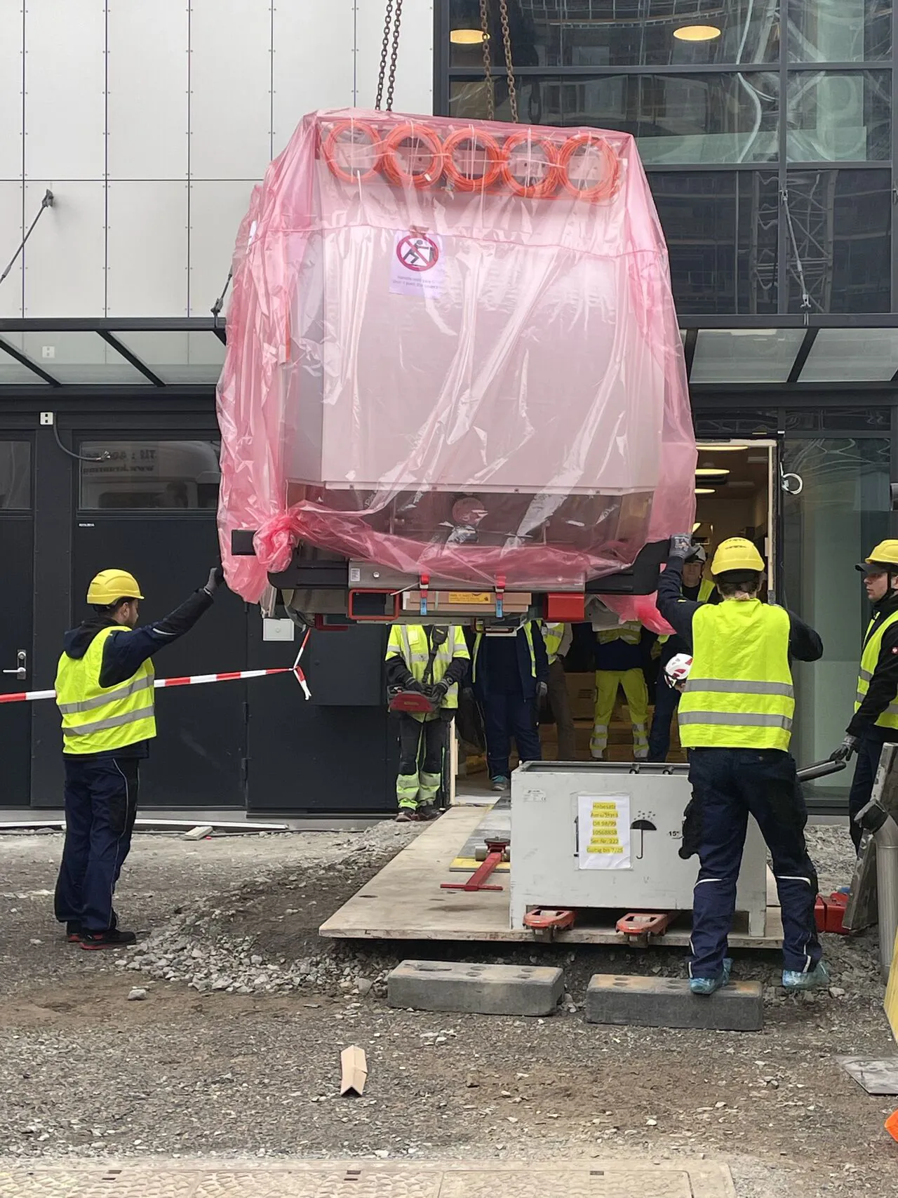 En gruppe arbeidere i gule vester som jobber med et stort utstyr