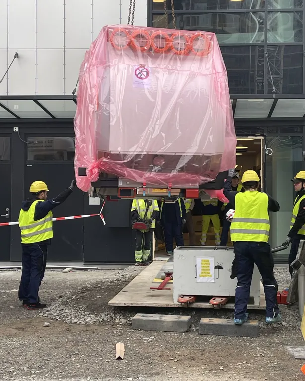 En gruppe arbeidere i gule vester som jobber med et stort utstyr