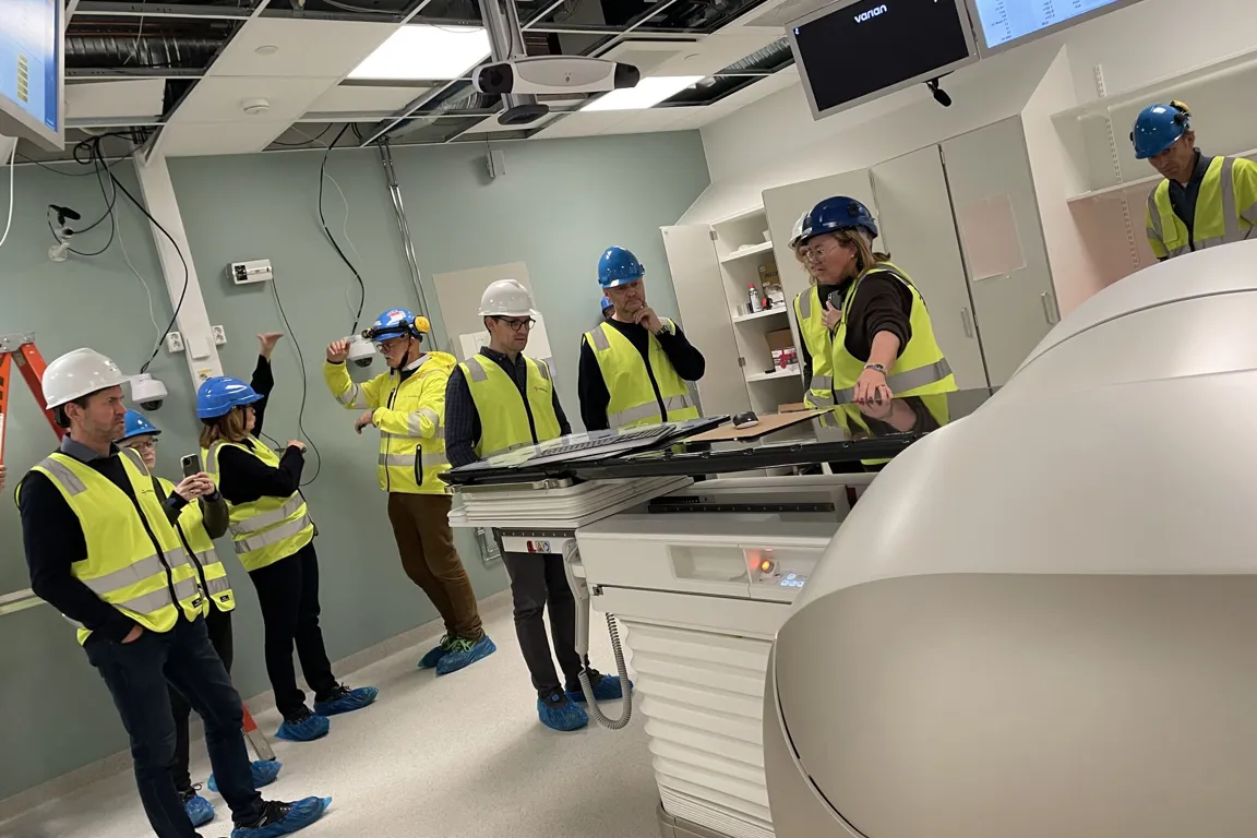 En gruppe mennesker i sikkerhetsvester som står i et rom