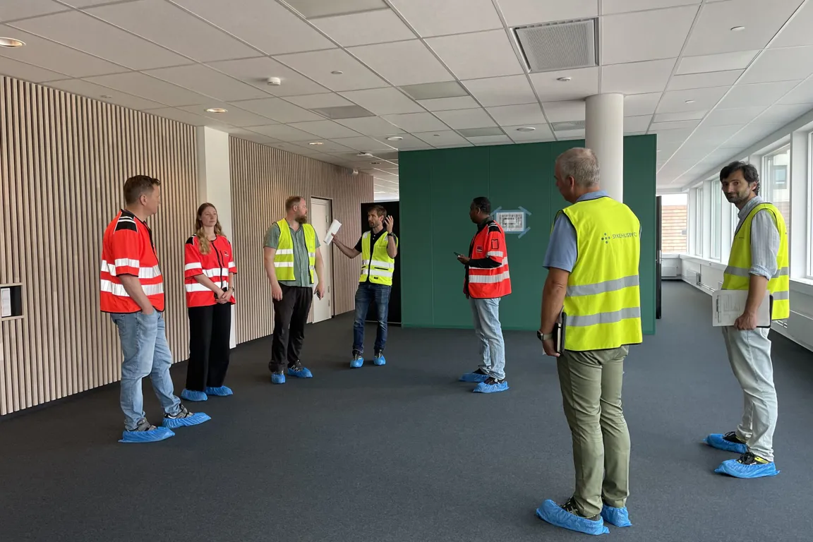 En gruppe mennesker som står i et rom