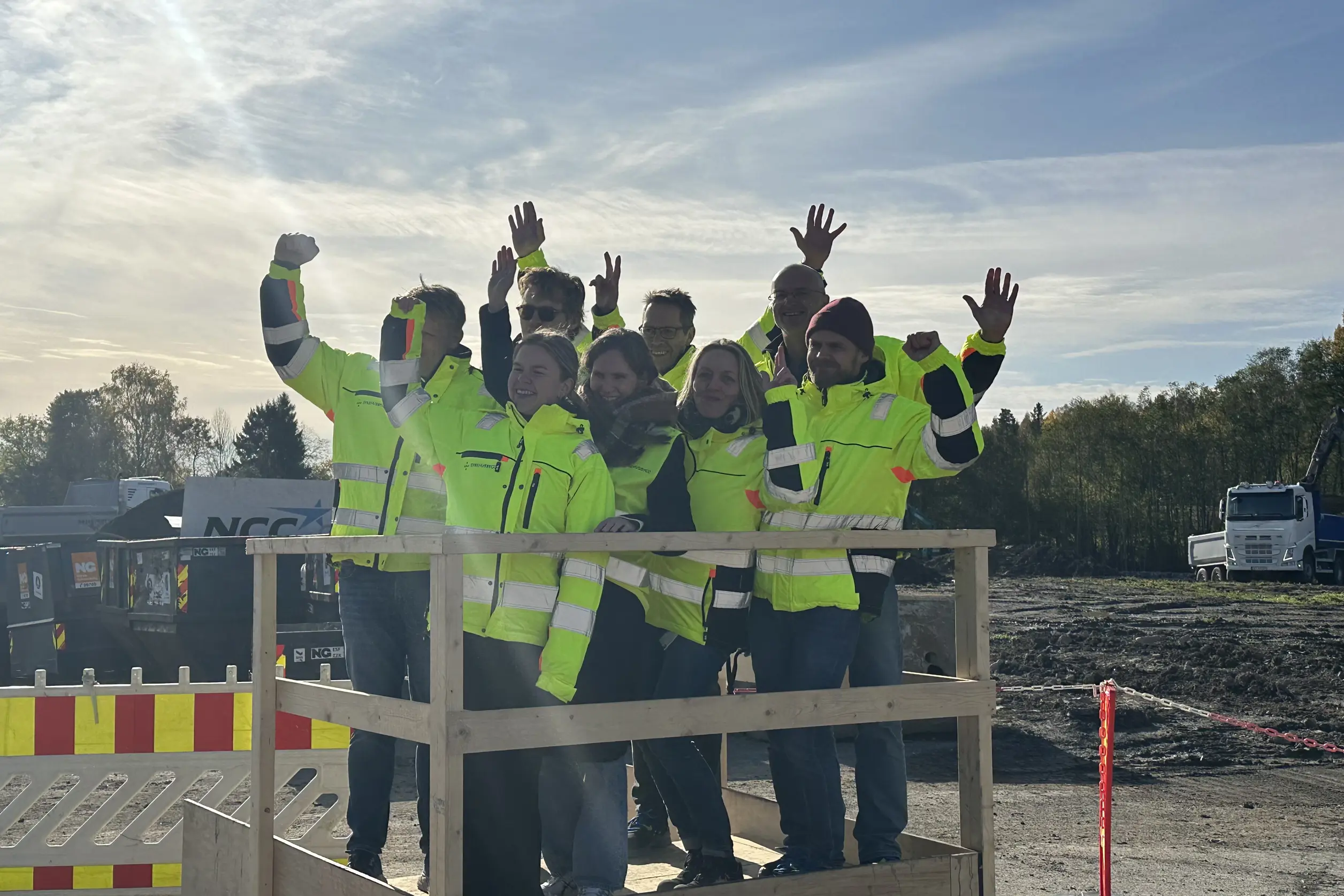 En gruppe brannmenn rekker opp hånden