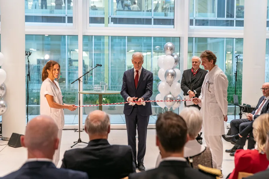 En mann og kvinne som står på et podium med en mikrofon foran en gruppe mennesker